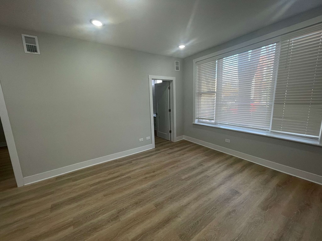 a living room with a large window and wooden floors