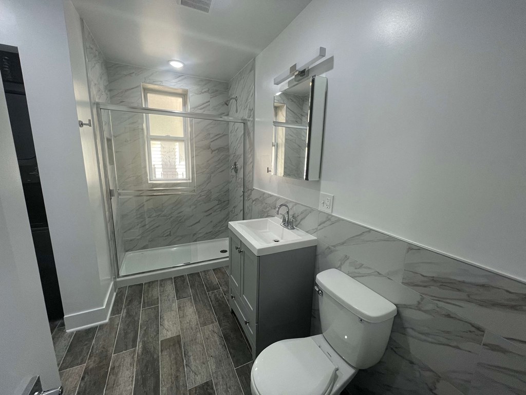 a bathroom with a toilet and a sink and a shower