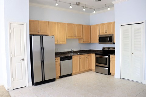 a kitchen with wooden cabinets and stainless steel appliances