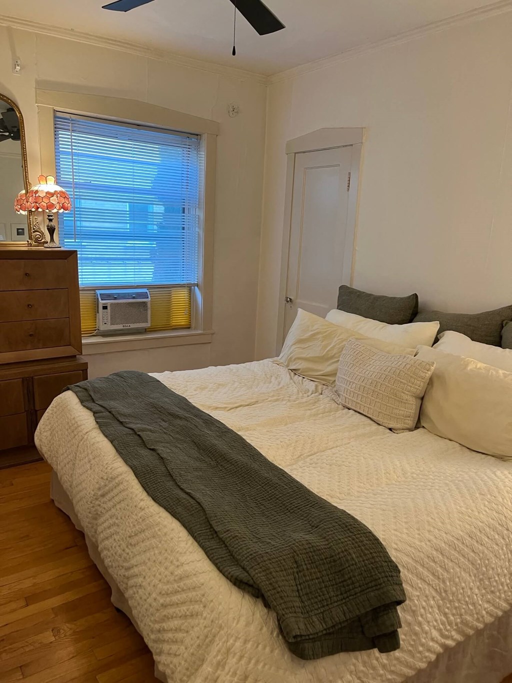 a bedroom with a bed and a dresser and a window