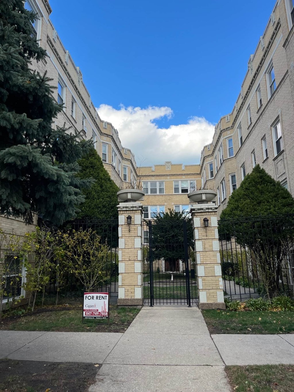 a gate with a sign in front of an apartment building