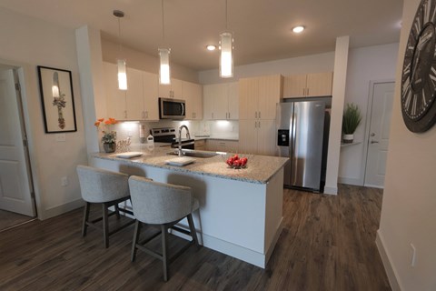 a kitchen with white cabinets and a marble counter top