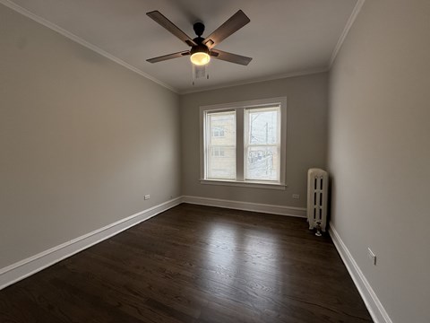 A room with a ceiling fan and a window.
