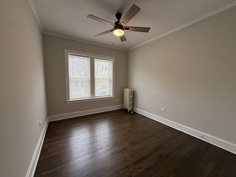 A room with a ceiling fan and a window with blinds.