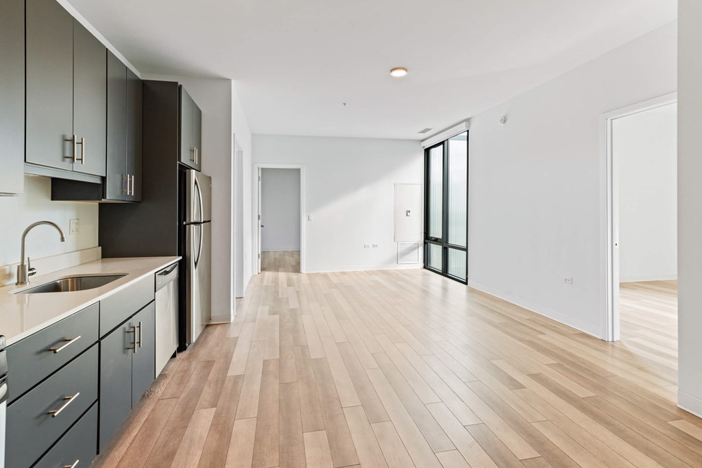 A kitchen with wooden floors and a white wall.