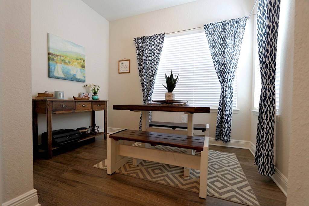 A room with a table and a painting on the wall.