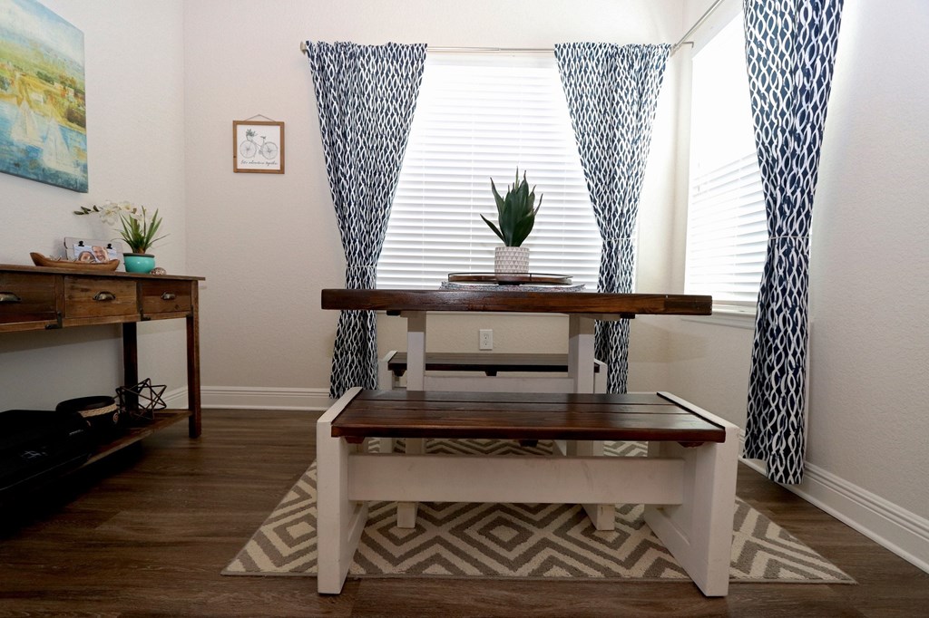 A room with a wooden table and a plant on it.
