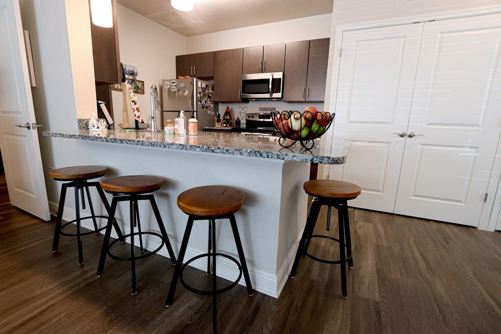 A kitchen with a bar and stools.