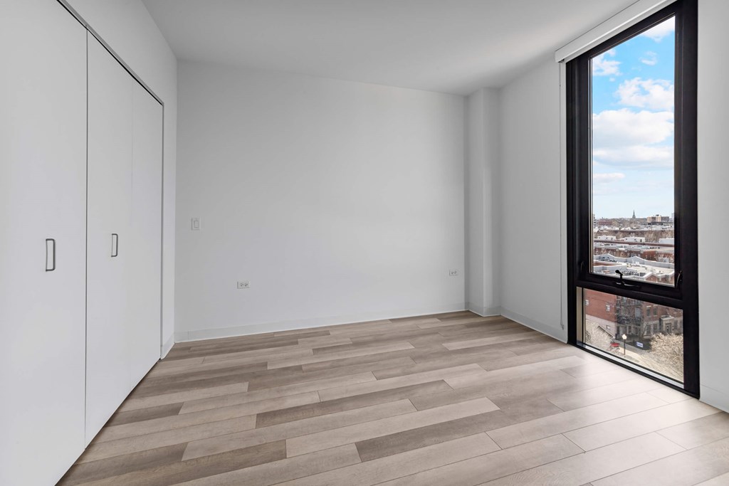 A room with a sliding door leading to a balcony.