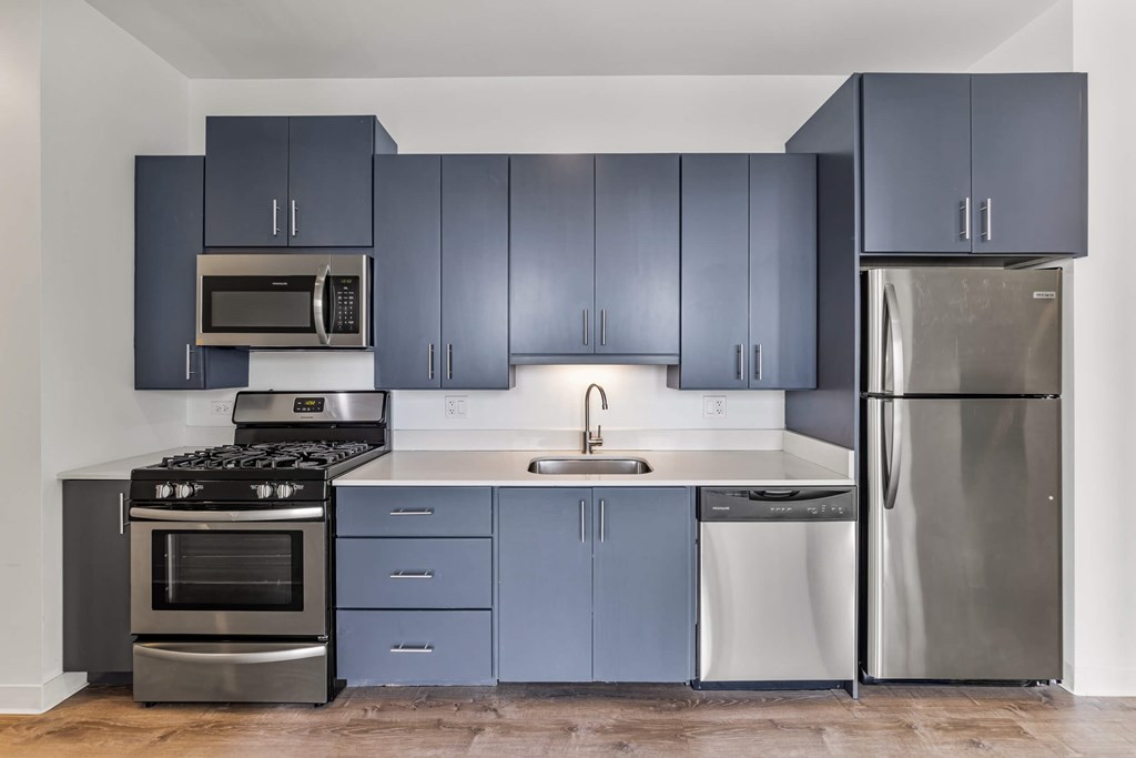 A kitchen with a stove, oven, sink, and refrigerator.