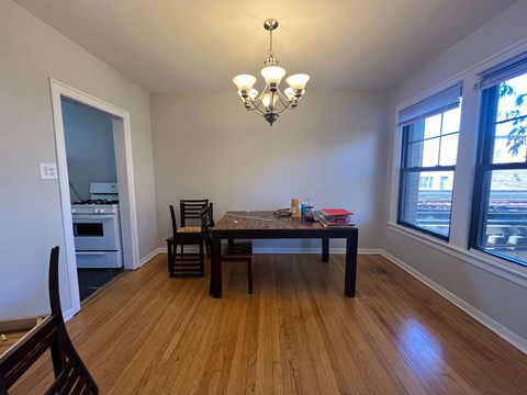 A dining room with a table and chairs.