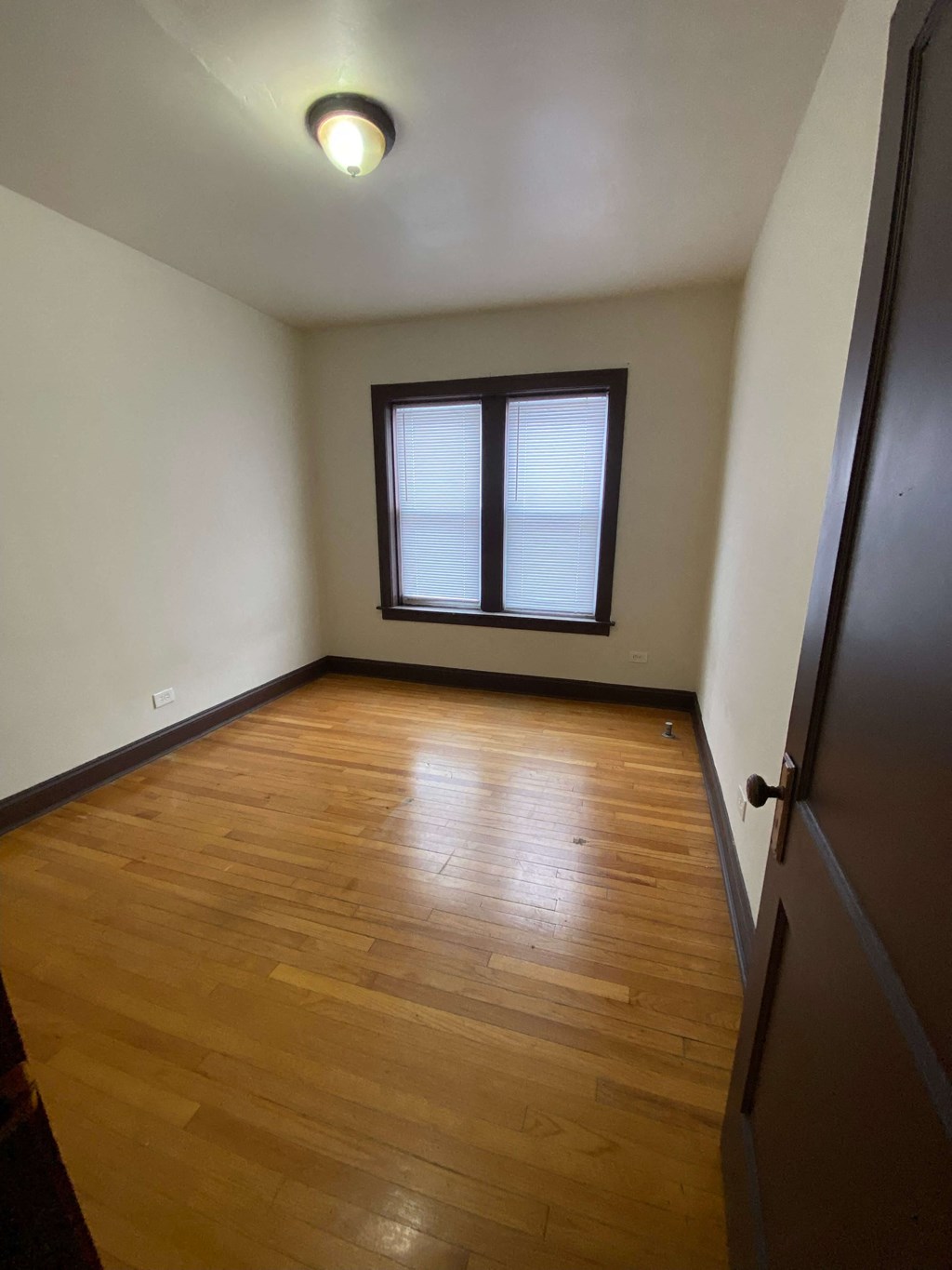 an empty room with wooden floors and a window