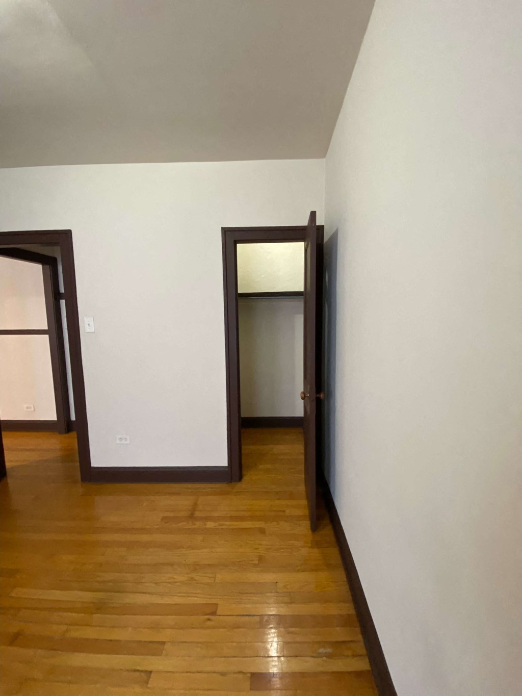 an empty room with wooden floors and white walls
