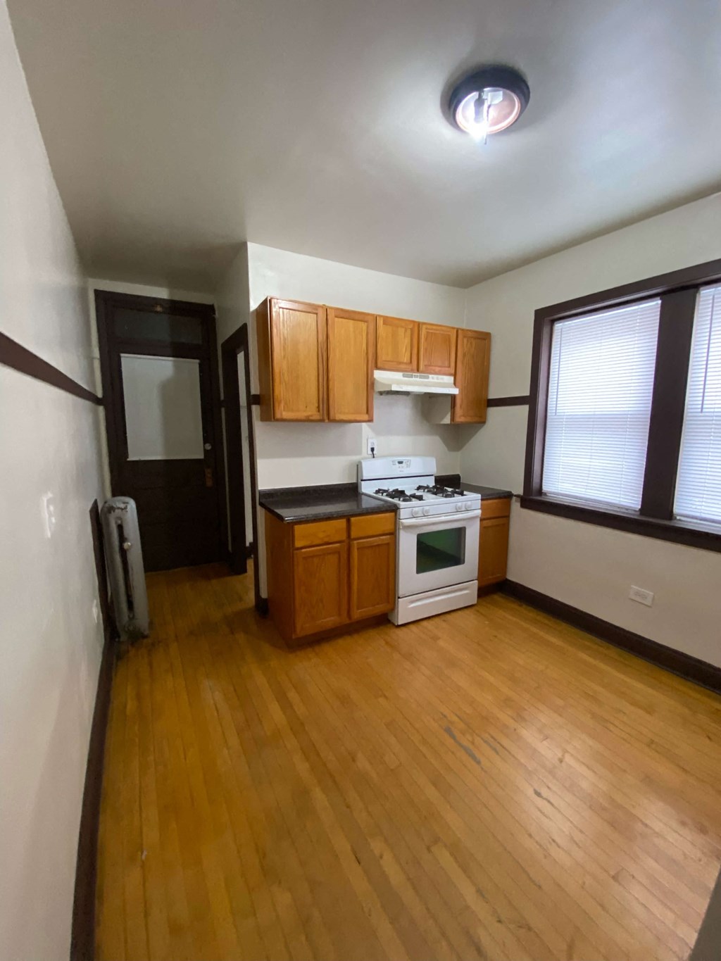 an empty kitchen with wooden floors and wooden cabinets