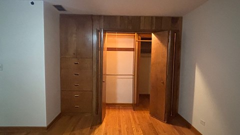 A kitchen with a refrigerator and wooden cabinets.