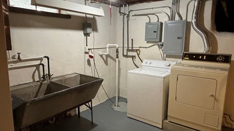 A bathroom with a toilet, sink, and washing machine.