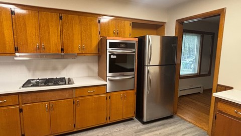 A kitchen with wooden cabinets and stainless steel appliances.