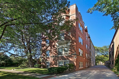 a tall brick building with trees in front of it