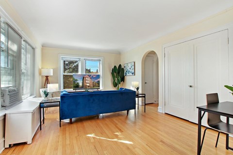 A bedroom with a blue bed and wooden floors.