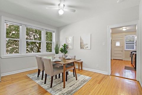A dining room with a table and chairs.