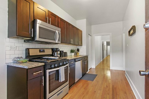 A kitchen with dark wood cabinets and a black stove top oven.