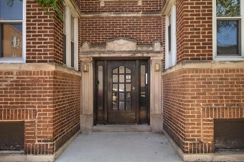 A brown door is in a brick building.