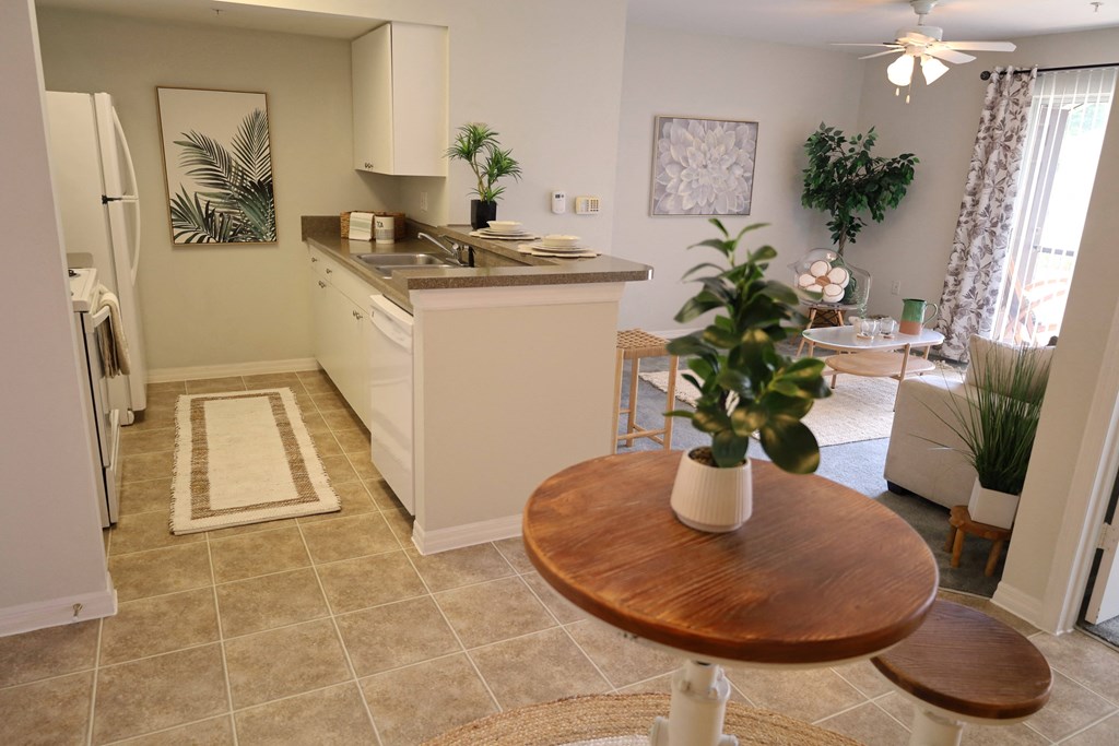 a kitchen and living room with a dining room table and a sink