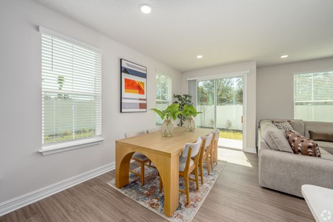 A dining room with a wooden table and chairs.