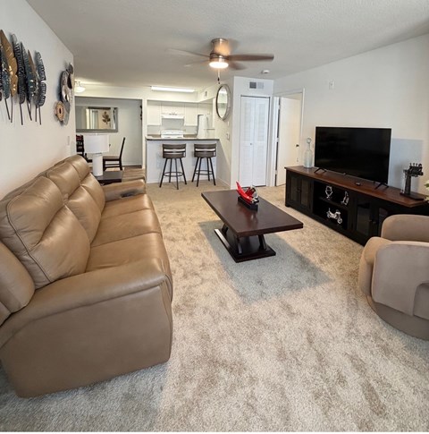 A living room with a brown leather couch and a wooden coffee table.