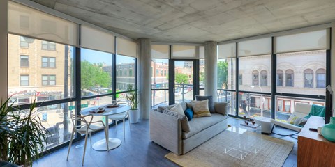 A living room with a couch, chairs, and a table with a plant in it.