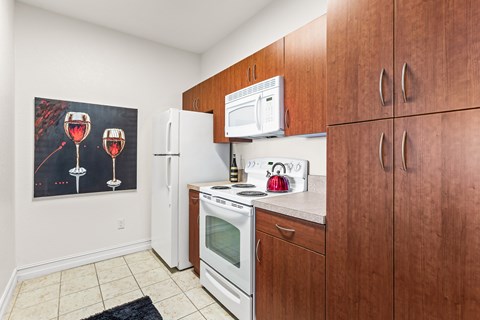 A kitchen with brown cabinets and a fridge.