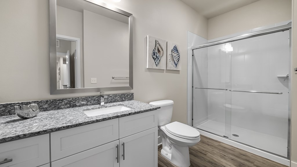 A bathroom with a toilet, sink, and shower.