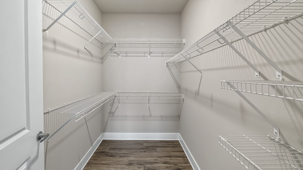 Empty walk-in pantry with white walls and shelving.