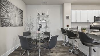 A modern dining room with a glass table and chairs.