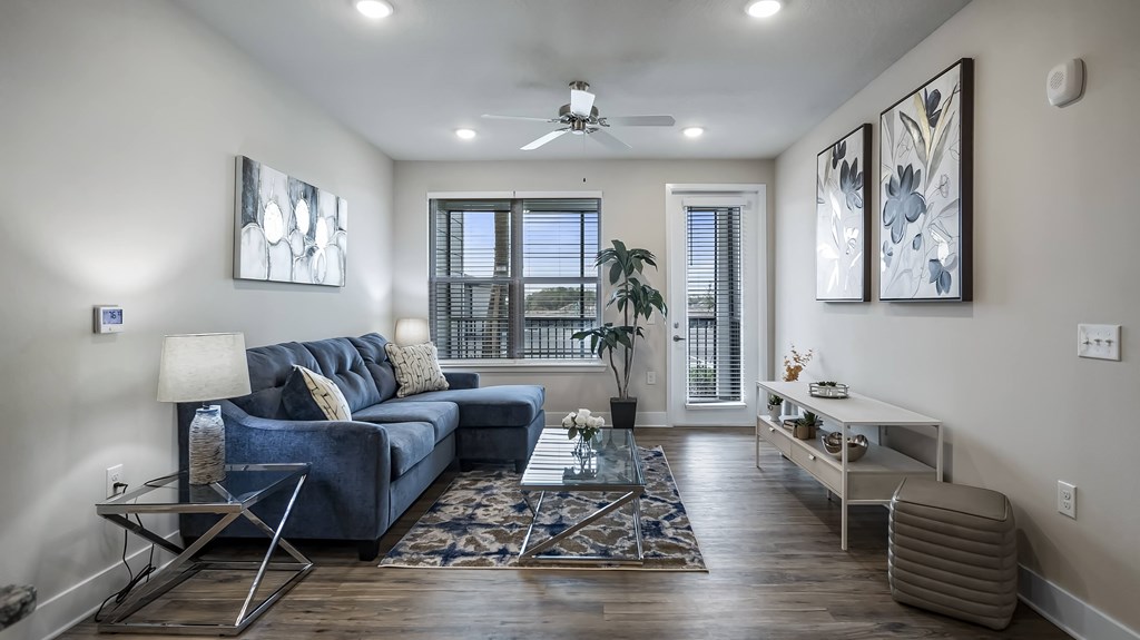 A living room with a blue couch and a rug.