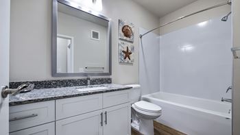 A bathroom with a white toilet, sink, and bathtub.