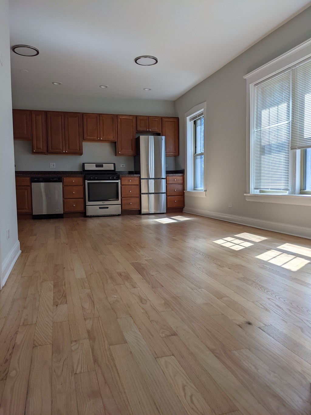 A kitchen with wooden cabinets and a refrigerator.