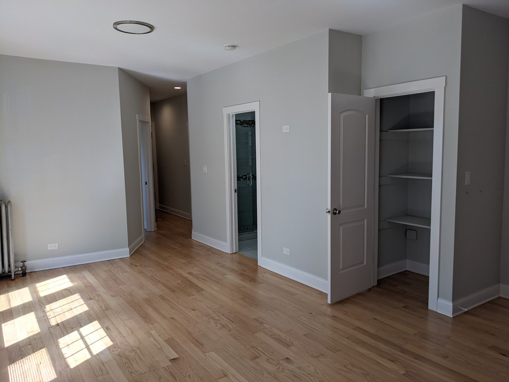 A room with a wooden floor and a white ceiling with a recessed lighting fixture.