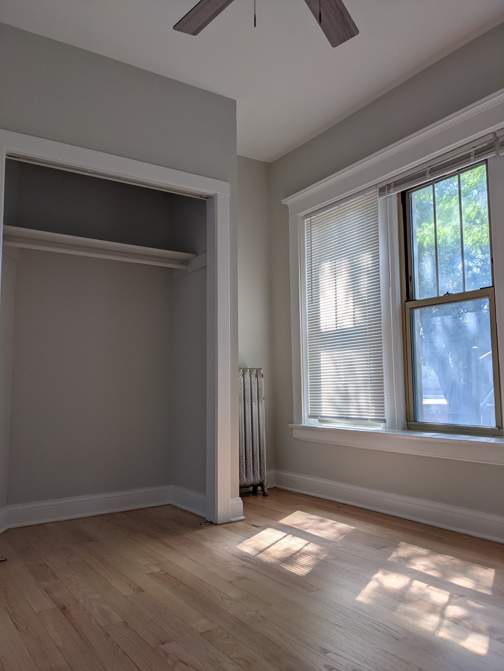 A room with a window and a radiator on the wall.