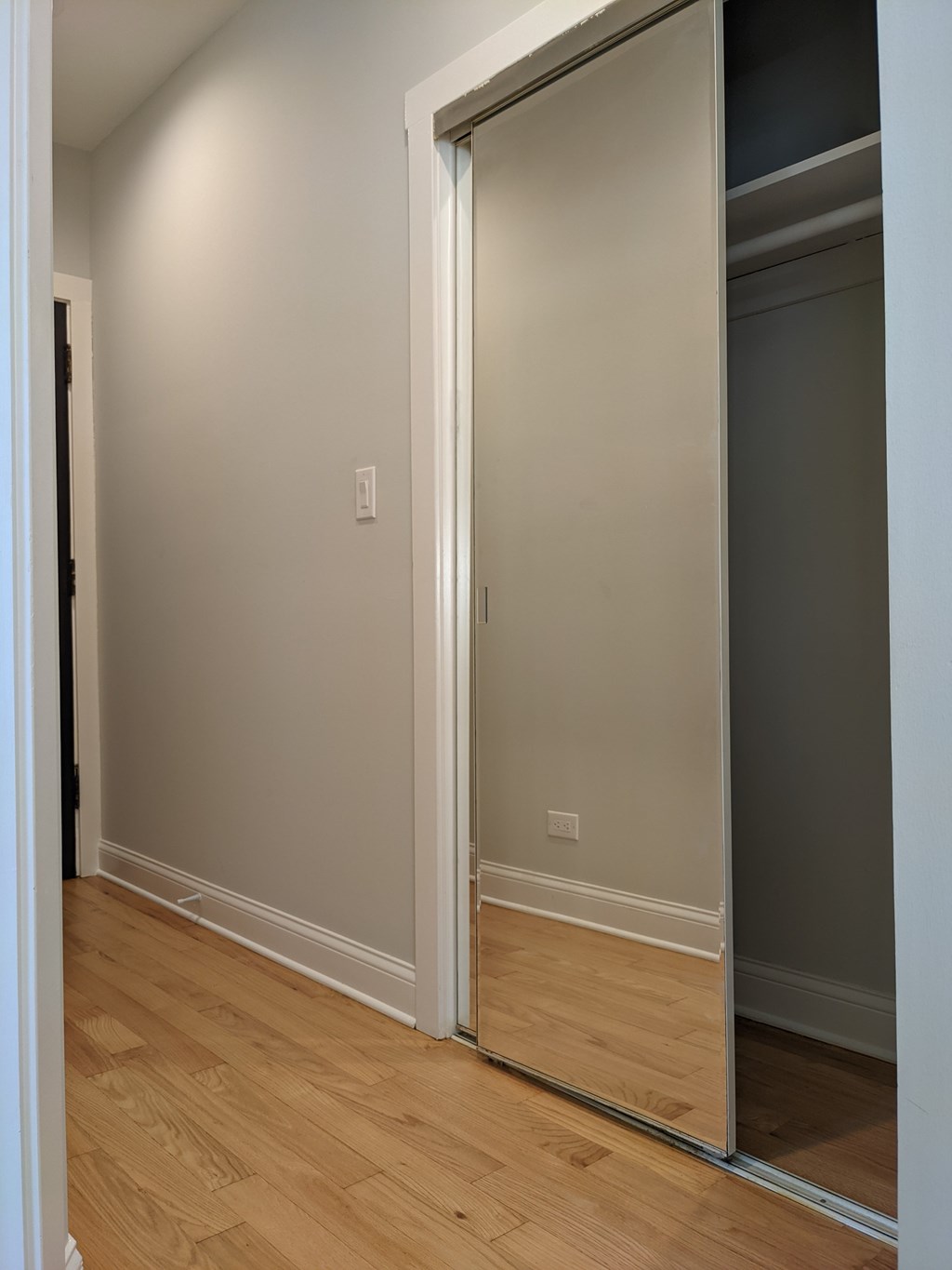 A white door is open in a room with wooden floors.