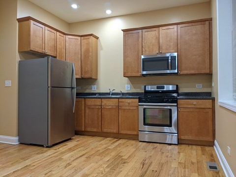 A kitchen with wooden cabinets and a black stove top oven.