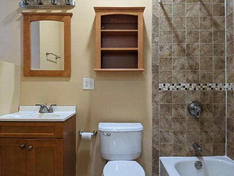 A bathroom with a toilet, sink, and shower.