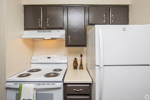 A kitchen with a white fridge, white stove and white oven.