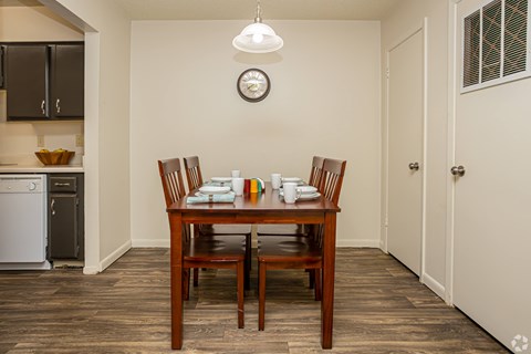 A dining room with a wooden table and chairs.