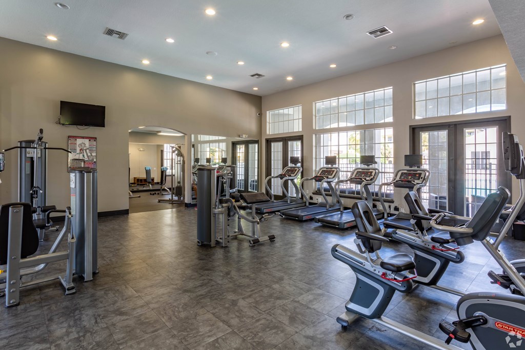 A gym with treadmills, elliptical machines, and other exercise equipment.