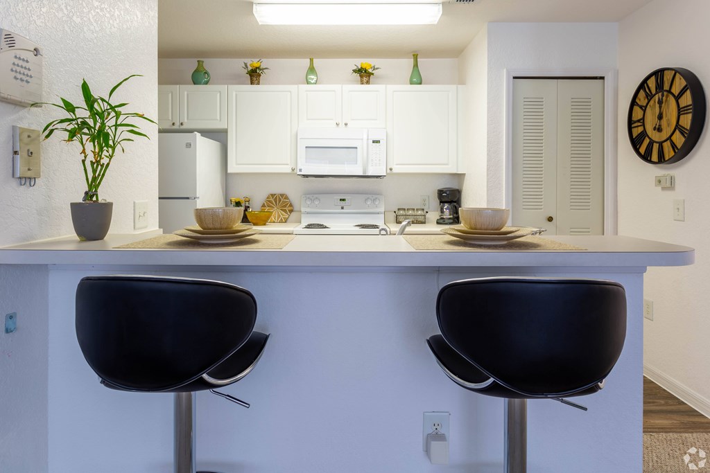 A kitchen with white cabinets and a white counter top.