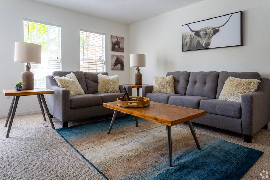 A living room with a grey couch and a wooden coffee table.