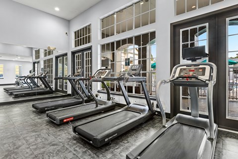 A gym with treadmills and elliptical machines.