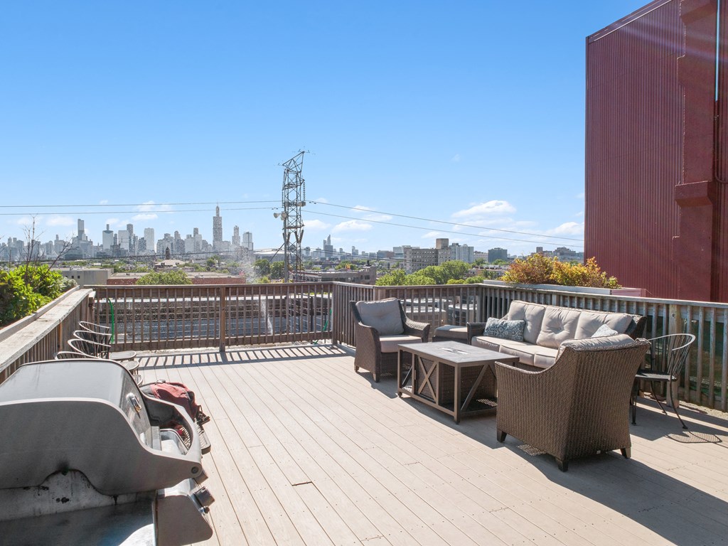 a roof deck with furniture and a view of the city