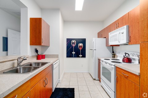 A kitchen with wooden cabinets and a fridge.